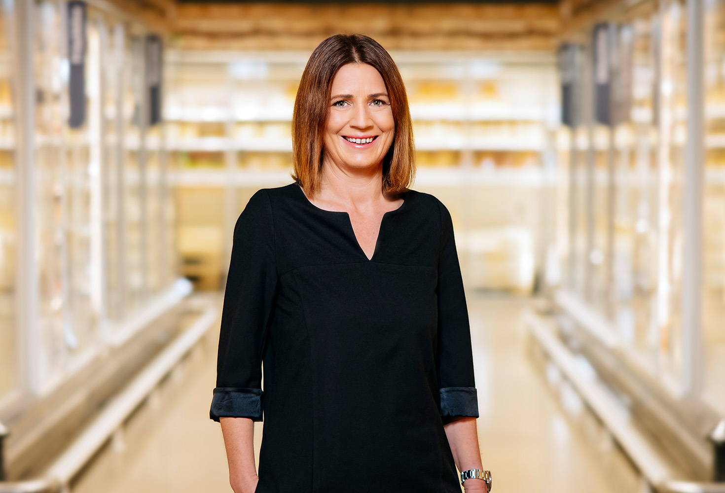 Christiane Giesen steht in der Kühlabteilung in einem METRO und lächelt in die Kamera (Foto)