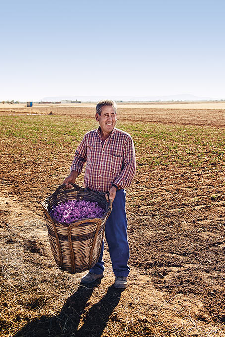 Mann hält stolz einen Korb seiner Ernte (Foto)